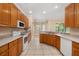 Bright kitchen with ample counter space, wood cabinets, white appliances, and tile flooring at 3779 N Econlockhatchee Trl, Orlando, FL 32817