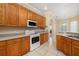 Kitchen area with wooden cabinetry, stainless steel sink, and white tiled floor at 3779 N Econlockhatchee Trl, Orlando, FL 32817
