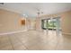 Spacious living room with tile flooring, ceiling fan, and access to kitchen and outdoor patio at 3779 N Econlockhatchee Trl, Orlando, FL 32817