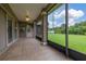 An outdoor covered patio features tile floors and a screened enclosure with an expansive view of the backyard at 3779 N Econlockhatchee Trl, Orlando, FL 32817