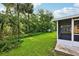 A view of the backyard featuring lush greenery and mature trees, enhancing the property's privacy at 395 Alcazar Ave, De Leon Springs, FL 32130