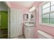 Bright bathroom with a white vanity, granite counters, and ample natural light from a window at 395 Alcazar Ave, De Leon Springs, FL 32130