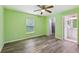 Green bedroom features wood-look floors, ceiling fan, and ensuite bath at 395 Alcazar Ave, De Leon Springs, FL 32130