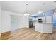 Dining area showcasing modern lighting and adjacent kitchen with stainless steel appliances and white cabinetry at 395 Alcazar Ave, De Leon Springs, FL 32130