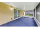 Enclosed lanai with carpeted floor and large sliding glass doors at 395 Alcazar Ave, De Leon Springs, FL 32130