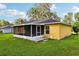 The screened porch adds a relaxed outdoor living space, surrounded by a well-maintained green lawn at 395 Alcazar Ave, De Leon Springs, FL 32130