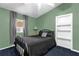 Bedroom featuring blue carpet, green walls, a full sized bed, and ample natural light at 4133 Cepeda St, Orlando, FL 32811