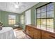 Sun room features multiple windows, tile floors, a ceiling fan, and a vintage wooden dresser at 4133 Cepeda St, Orlando, FL 32811