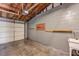 Unfinished basement with exposed wood ceiling, concrete walls and floors, and garage door access at 441 S Primrose Dr, Orlando, FL 32803