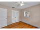 Neat bedroom featuring hardwood floors, a ceiling fan, and a closet with louvered doors at 441 S Primrose Dr, Orlando, FL 32803
