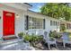 Inviting entrance with a vibrant red door, neat landscaping, and charming seating at 441 S Primrose Dr, Orlando, FL 32803