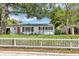 Charming single-story home with a bright red door, white picket fence, and lush landscaping at 441 S Primrose Dr, Orlando, FL 32803