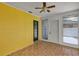 Bright sunroom with tile flooring, ceiling fan, yellow accent wall, and doors leading to the outside at 441 S Primrose Dr, Orlando, FL 32803