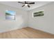 Empty bedroom features a ceiling fan, hardwood floors, and ample natural light from the windows at 501 Benedict Ct, Casselberry, FL 32707