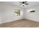 Neutral bedroom featuring wood floors, two windows, and a ceiling fan at 501 Benedict Ct, Casselberry, FL 32707