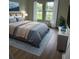 Calming bedroom featuring a plush bed, soft colors, and natural light from two large windows at 524 Marion Oaks Blvd, Ocala, FL 34473
