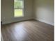 Bright bedroom with wood-look flooring and a large window offering a pleasant view at 524 Marion Oaks Blvd, Ocala, FL 34473
