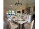 Open-concept dining area with a marble-top table, seating for six, and modern chandelier above at 524 Marion Oaks Blvd, Ocala, FL 34473