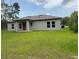 Rear exterior of house features a neutral paint scheme, manicured lawn, and access to outdoor enjoyment at 524 Marion Oaks Blvd, Ocala, FL 34473
