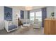 Charming Bedroom with two cribs, stylish decor, and a cozy seating area near the window at 6005 Blue View Way, St Cloud, FL 34771