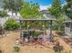 View of the backyard with a covered pergola, grill, chairs, and mature landscaping providing a cozy retreat at 6902 Coral Cove Dr, Orlando, FL 32818