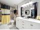 Bright bathroom with a double sink vanity, updated fixtures, and a shower with colorful curtain at 6902 Coral Cove Dr, Orlando, FL 32818