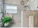 Clean bathroom featuring a rainfall shower head, tiled walls, and a decorative nautical theme at 6902 Coral Cove Dr, Orlando, FL 32818