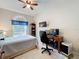 Bedroom featuring a ceiling fan, large window, desk with monitors, and tile flooring at 6902 Coral Cove Dr, Orlando, FL 32818