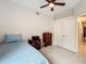 Cozy bedroom featuring a ceiling fan, tiled floor, closet, dresser and comfortable bed at 6902 Coral Cove Dr, Orlando, FL 32818