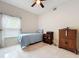 Comfortable bedroom with a ceiling fan, tiled floors, dresser, and lots of natural light at 6902 Coral Cove Dr, Orlando, FL 32818