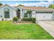 Charming single-story home features a manicured lawn, two-car garage, and a beautiful light blue exterior at 6902 Coral Cove Dr, Orlando, FL 32818