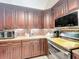 Well appointed kitchen with stainless steel appliances, granite countertops and brown cabinetry at 6902 Coral Cove Dr, Orlando, FL 32818
