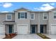 Townhome exterior with grey facade, blue door and shutters, white garage door, and meticulously manicured landscaping at 712 Preston Cove Dr, St Cloud, FL 34771