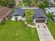 Aerial view of a single-Gathering home featuring an attached garage and beautiful landscaping at 8676 Hillside Dr, Orlando, FL 32810