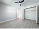 This bedroom features an open closet, gray walls, modern wood-look floors, and fan at 8676 Hillside Dr, Orlando, FL 32810