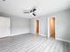 Bedroom features wood-look floors, ceiling fan, and access to closets at 8676 Hillside Dr, Orlando, FL 32810