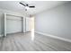 A well-lit bedroom features an open closet with shelving and modern wood-look floors at 8676 Hillside Dr, Orlando, FL 32810