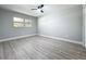 This bedroom features gray walls, wood-look floors, a window, and a ceiling fan at 8676 Hillside Dr, Orlando, FL 32810