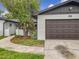 Charming single-Gathering home showcasing a well-maintained lawn, beautiful trees and attached garage at 8676 Hillside Dr, Orlando, FL 32810