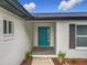 Charming single-Gathering home featuring a colorful front door, lush landscaping and window shutters at 8676 Hillside Dr, Orlando, FL 32810