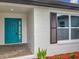 Welcoming front entrance with a bright blue door and white exterior at 8676 Hillside Dr, Orlando, FL 32810