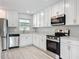 Bright kitchen with white cabinetry, stainless steel appliances, and modern finishes at 8676 Hillside Dr, Orlando, FL 32810