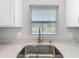 Close-up of kitchen sink under window with backyard and pool view at 8676 Hillside Dr, Orlando, FL 32810