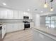 Bright kitchen with white cabinets, stainless steel appliances, and pendant lighting at 8676 Hillside Dr, Orlando, FL 32810