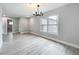 Bright living room with wood floors, modern lighting, and large window at 8676 Hillside Dr, Orlando, FL 32810