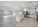 Open concept kitchen and living area with stainless appliances, island, and wood floors at 8676 Hillside Dr, Orlando, FL 32810