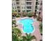Aerial view of a sparkling community pool surrounded by lush landscaping and condo buildings at 911 N Orange Ave # 440, Orlando, FL 32801