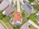 Aerial view of a home with a screened pool, neat landscaping, and an attractive, terracotta-colored roof in a residential neighborhood at 10360 Crystal Point Dr, Orlando, FL 32825