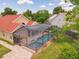 An aerial view of the screened-in pool with a spa and patio at 10360 Crystal Point Dr, Orlando, FL 32825