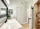 Bright bathroom featuring a vanity, mirror and a walk-in tiled shower at 10360 Crystal Point Dr, Orlando, FL 32825